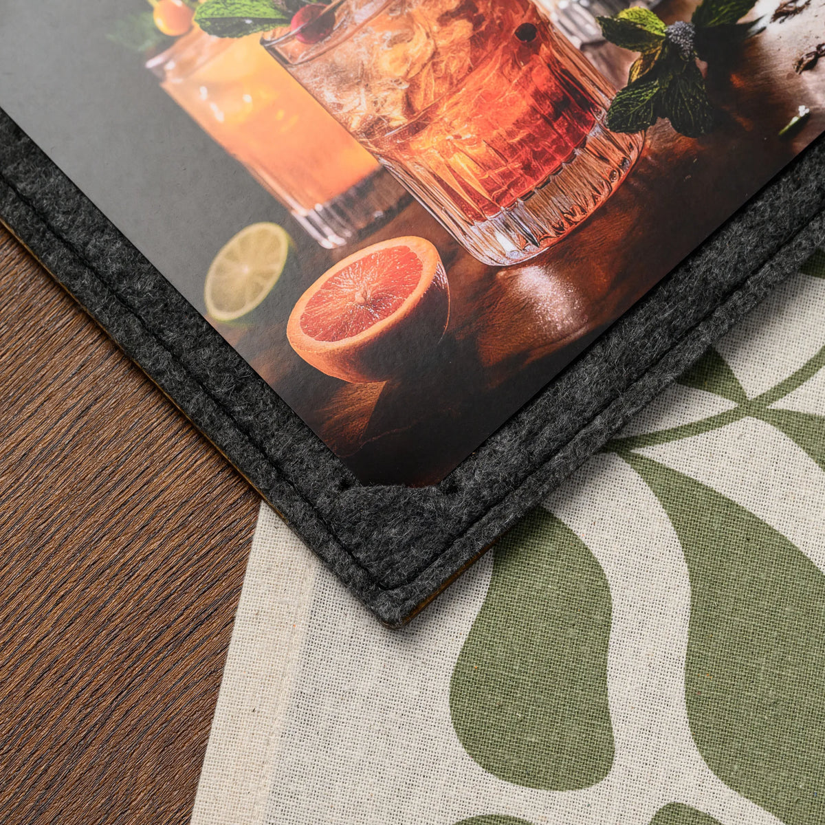 Фанерний планшет для меню з фетровою обкладинкою, крупний план нижнього кута: край аркуша у фетровому кутику та подвійна прострочка