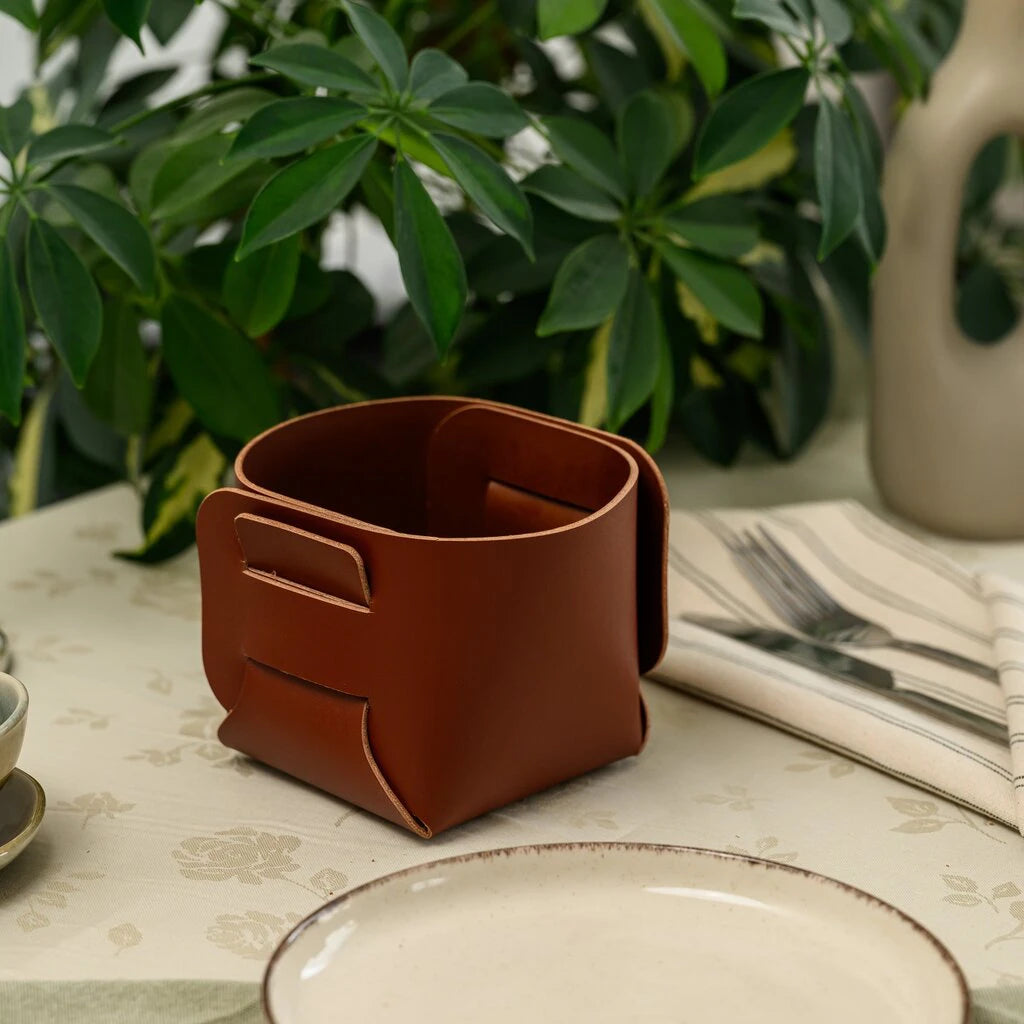 Minimalist cognac leather tabletop organizer showcasing a clever no-stitch interlocking design, perfect for a modern or rustic kitchen