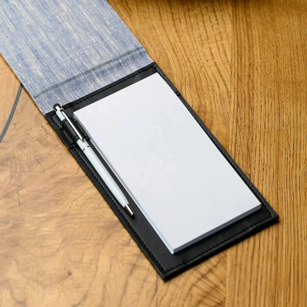 This image showcases a hardcover fabric journal, an indispensable tool for waiters. The notebook's resilient fabric cover and sturdy hardback provide a dependable surface for writing, even during the most demanding shifts in a busy restaurant.