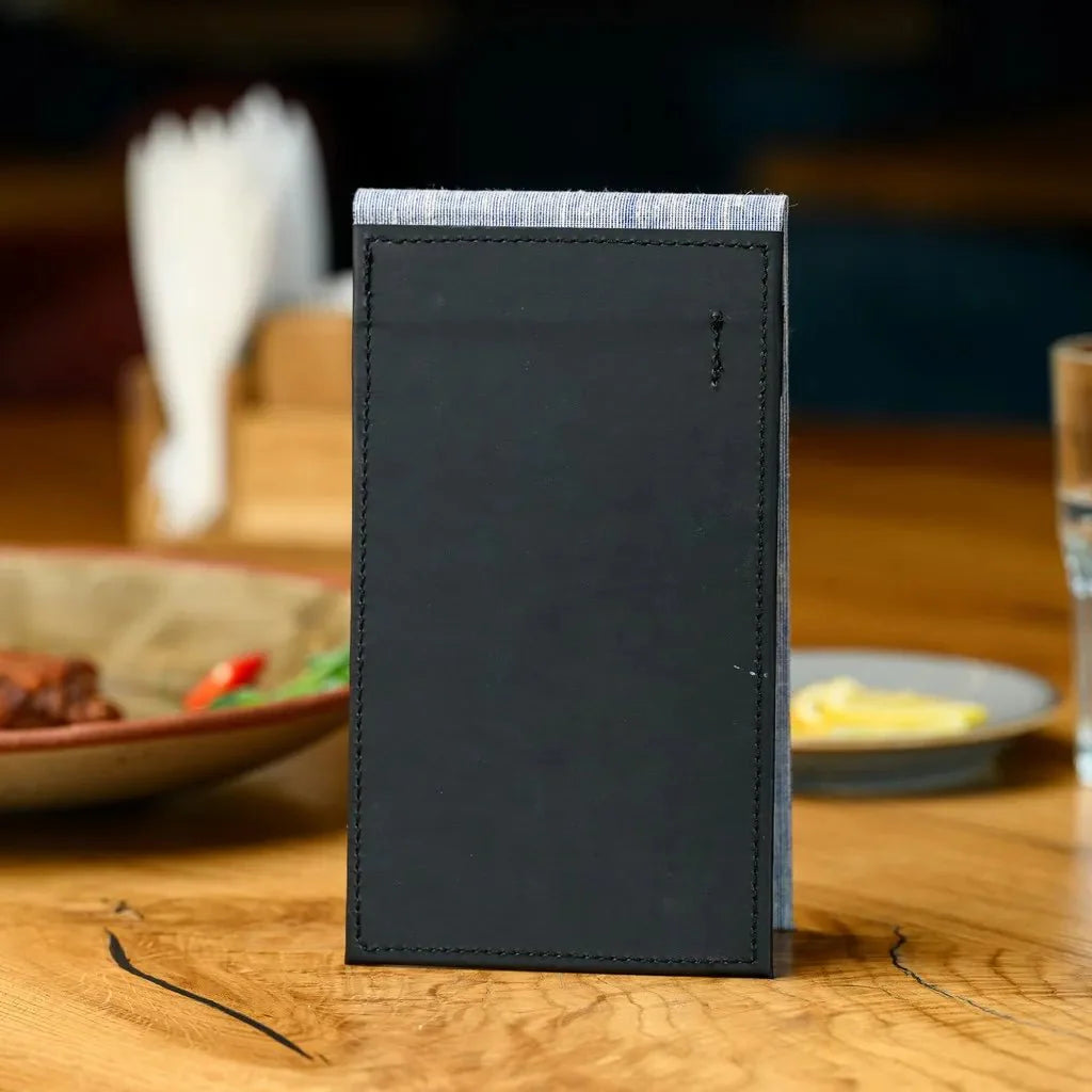 This professional-grade waiter's order book features a stylish fabric cover and a durable hardcover, combining aesthetic appeal with practical functionality. The notebook is designed to provide a reliable and long-lasting tool for managing customer orders.