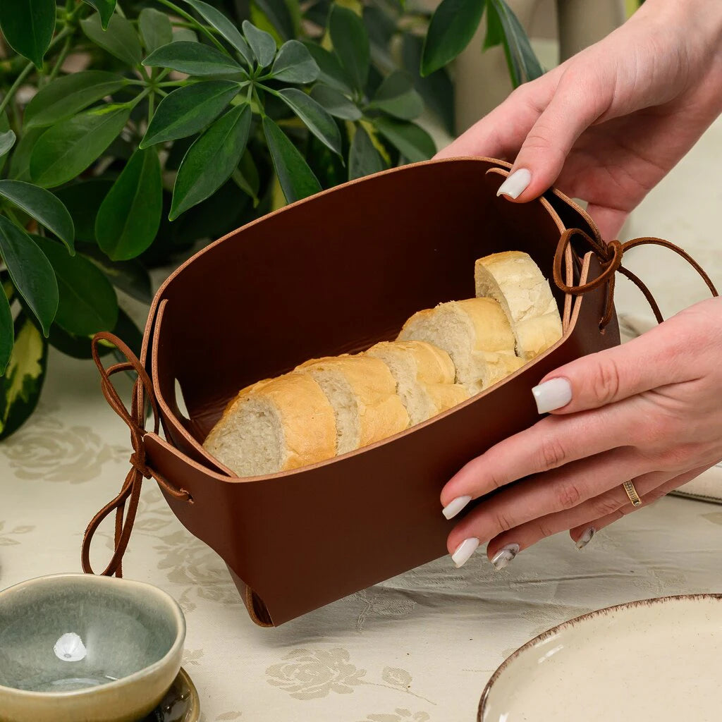 Genuine leather serving tray with functional leather string closures, foldable brown leather basket for kitchen and dining room decor.