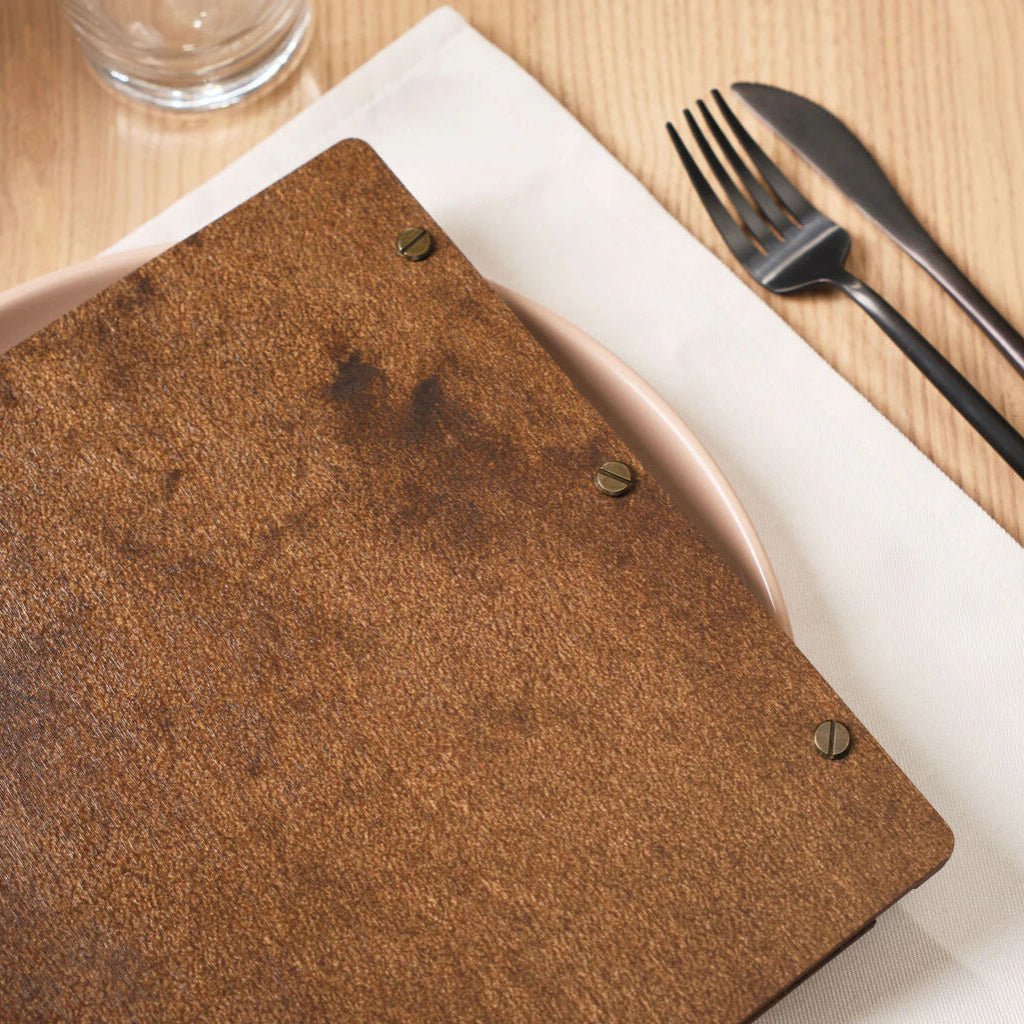 Handcrafted wooden menu folder with a topographic map pattern and black leather binding straps.