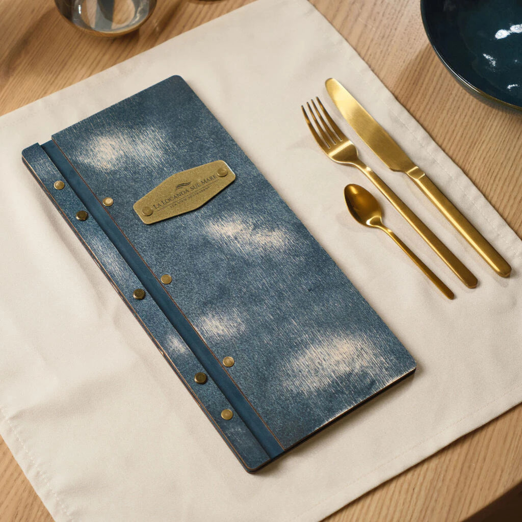Jeahs color wooden restaurant menu with gold cutlery on a white linen napkin.