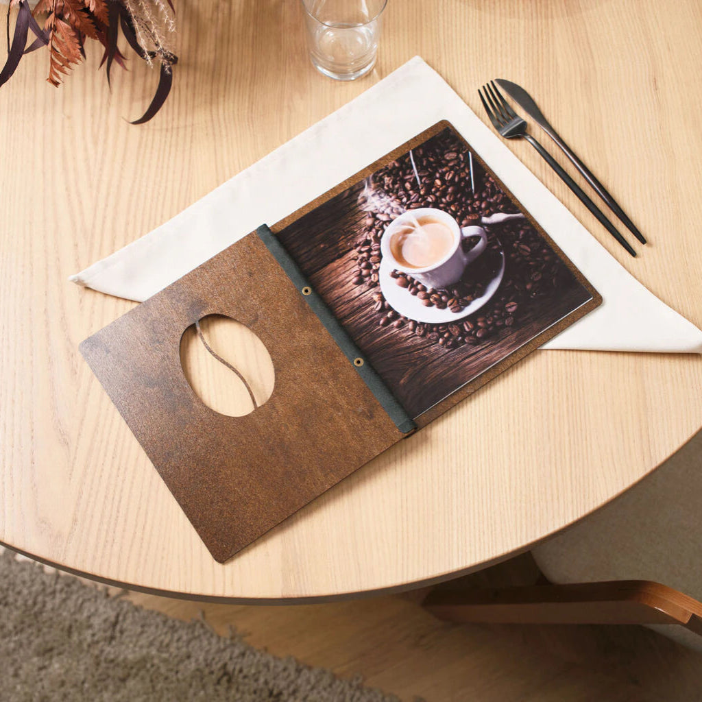 Customer pointing to a cocktail photo inside an open custom-designed wooden restaurant menu.