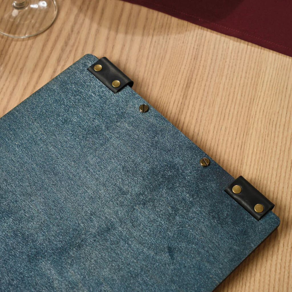Close-up of laser-etched "Reserved" lettering on a matte black acrylic plate for restaurant table management