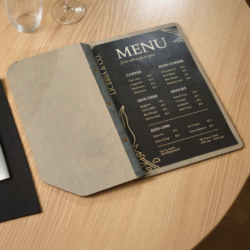 Professional wooden menu board open to show a sleek black menu insert with gold-tone lettering, featuring price lists for a variety of beverages and food items