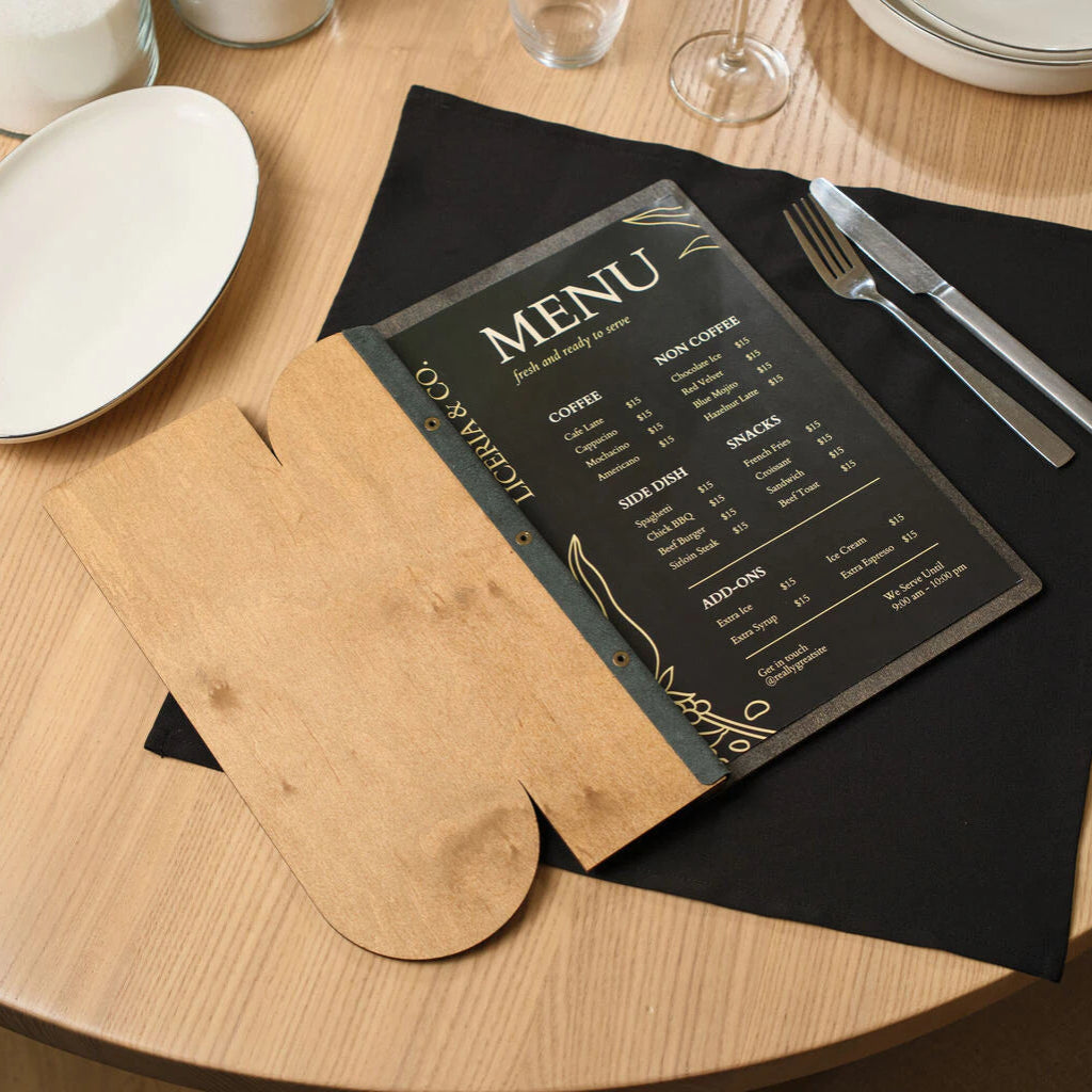 An open wooden menu folder with a custom cutout on a set table, made of natural oak with professional brass screw post binding.