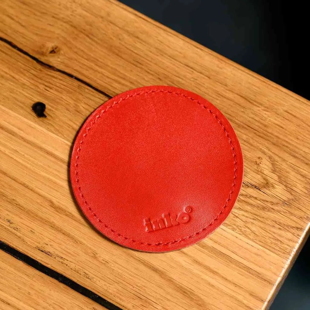 Елегантна кругла підставка зі шкіри Crazy Horse на робочому столі поруч із ноутбуком та чашкою кави.