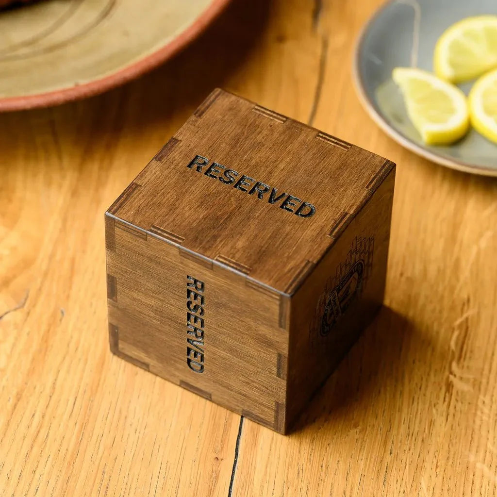 Custom wooden tabletop reserve plate with personalized branding.