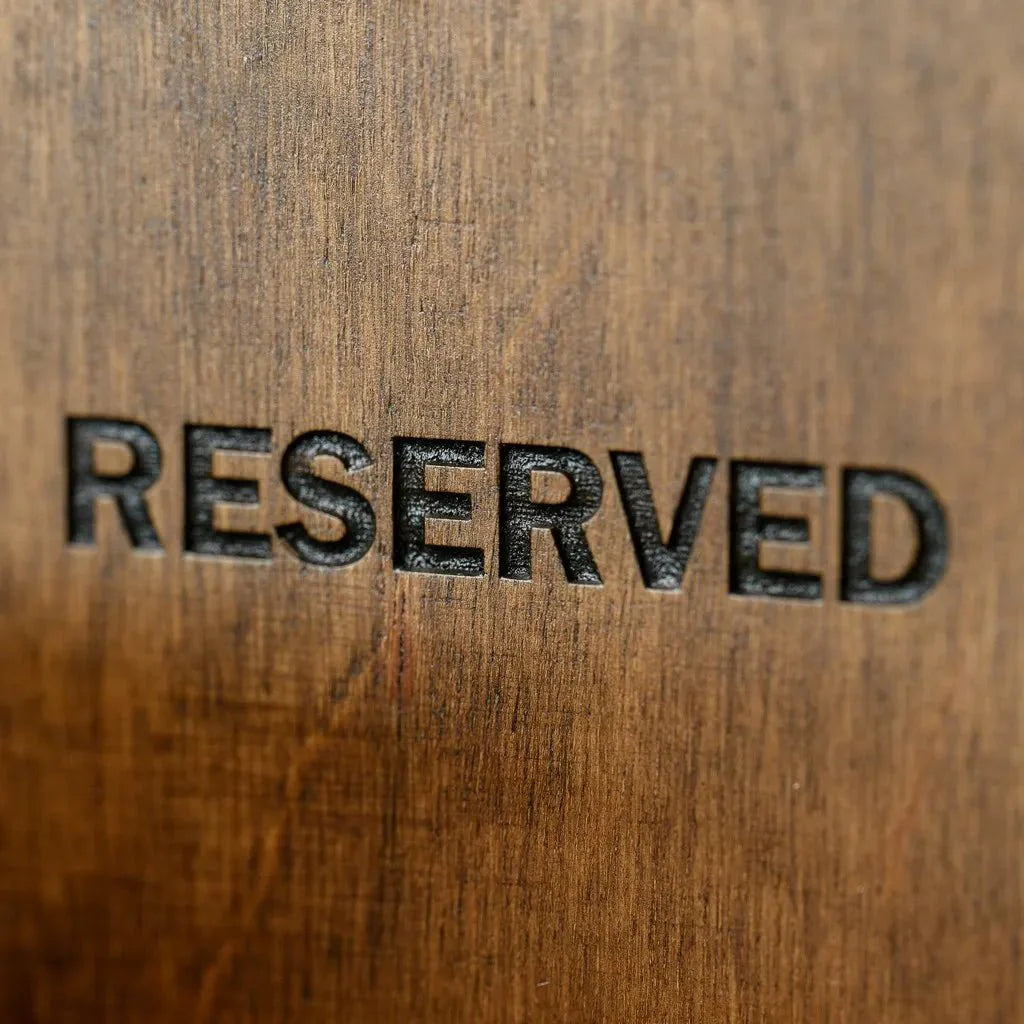Stylish wooden reserve plate for restaurant tabletops.