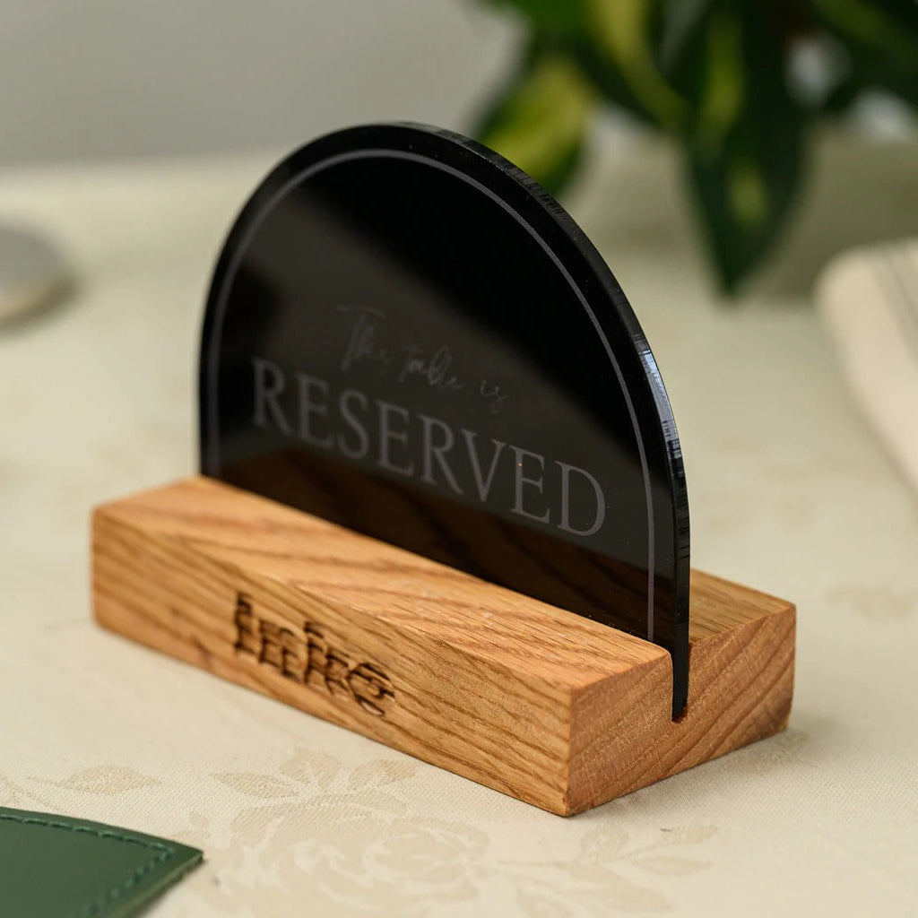 Modern restaurant table decor: an elegant semicircle 'Reserved' sign made of premium black acrylic and natural wood. A perfect blend of minimalist design and functionality for high-end cafes