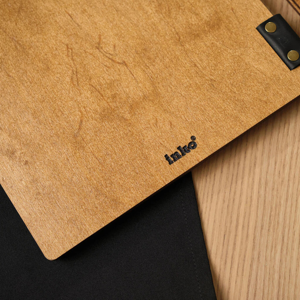 Macro photo of the bottom of a wooden folder, highlighting the natural oak texture and neat "inko" branding