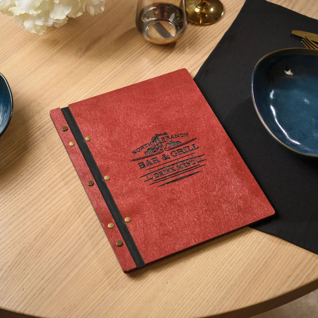 Custom red wooden menu folder for North Branch Bar & Grill. This handcrafted wood menu cover features black laser-engraved branding, a leather spine, and professional brass bolt binding