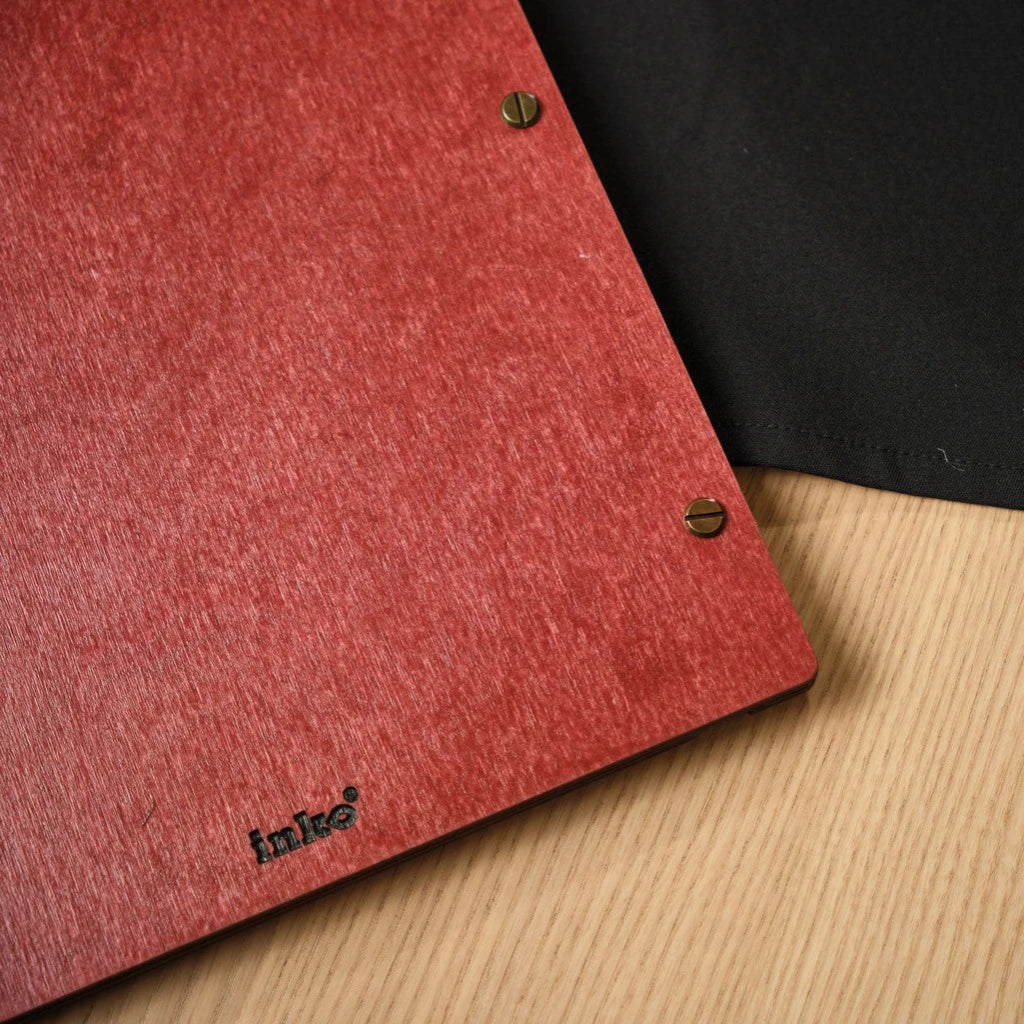 Close-up of the back of a red wooden menu folder featuring a small engraved logo and bronze screw-post binding. This handcrafted wood menu cover highlights the premium grain texture and professional metal hardware for high-end restaurant use