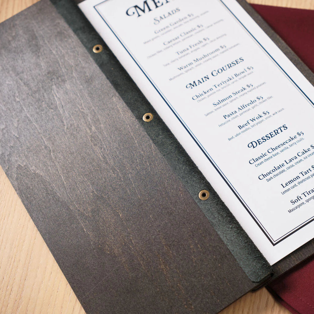 An angled close-up of the interior, showing the black leather spine strip with three brass-colored eyelets used to secure the menu pages