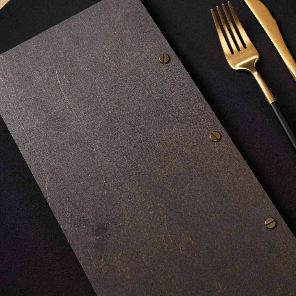 A detailed view of the back cover's binding, showing three slotted brass screws set into the dark wood for a secure, professional finish.