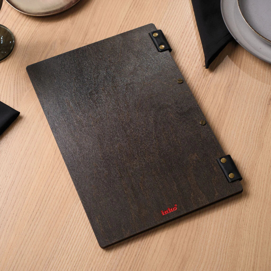 The back side of a wooden menu folder with a small red "inko" logo at the bottom and leather fasteners.