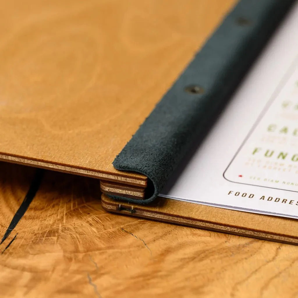 Personalized restaurant wooden menu covers with custom engraving.