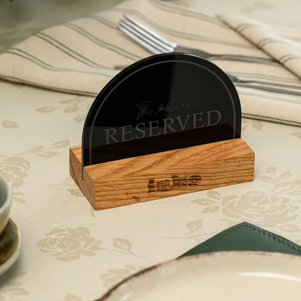 Elegant and minimalist 'Reserved' sign for modern restaurants. A sleek combination of engraved black acrylic and natural oak wood, perfect for professional table management