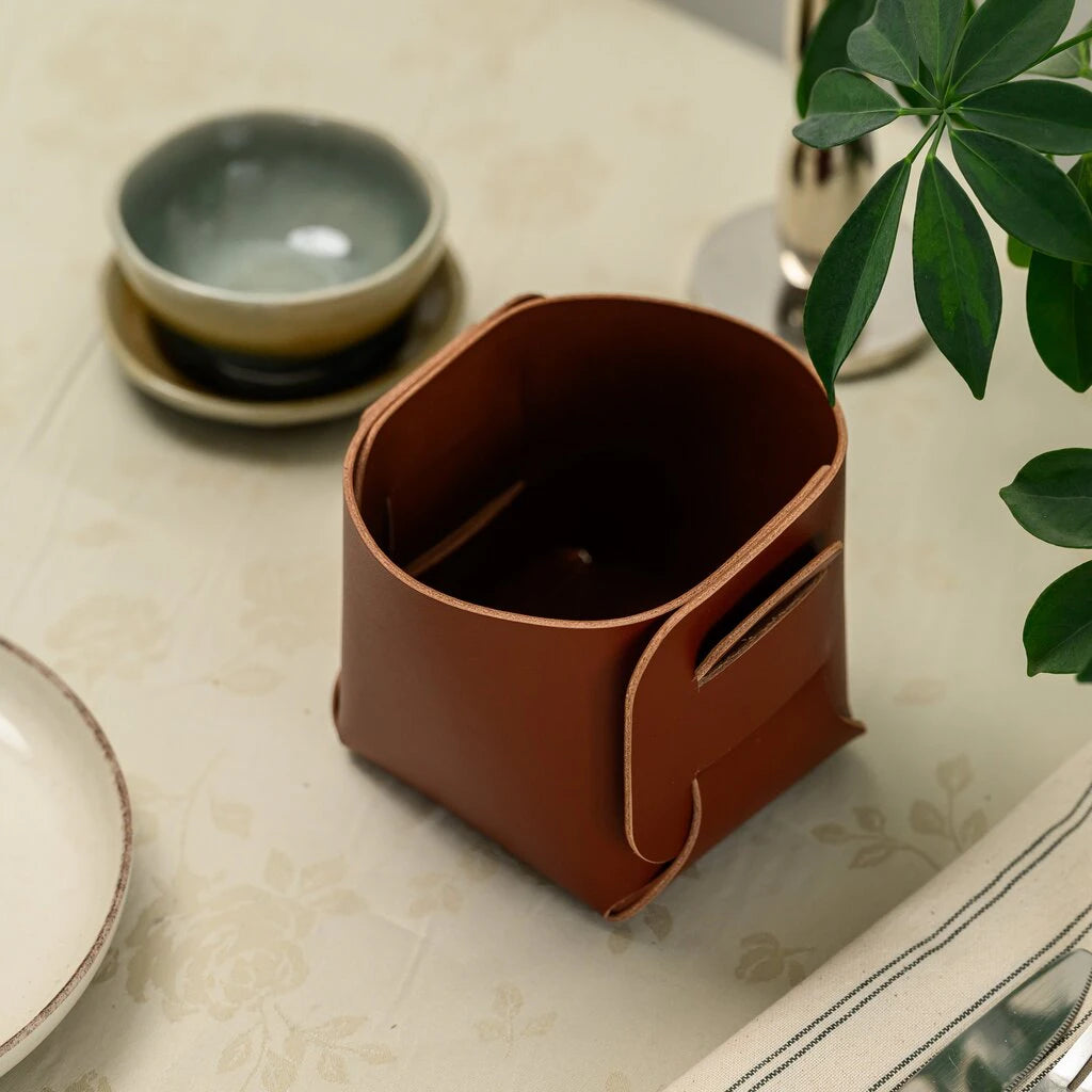 High-angle shot of a premium handcrafted leather valet tray or bread bin, showcasing the rich grain and seamless assembly of the material