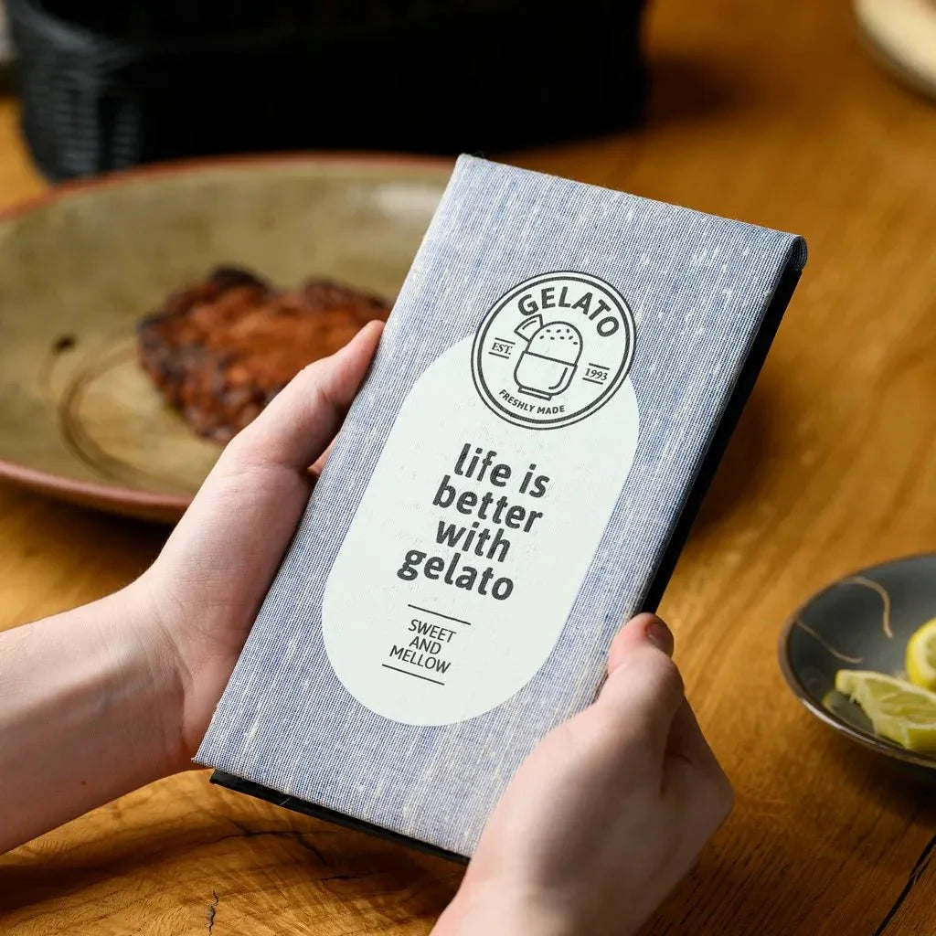A durable fabric-covered notebook with a robust hardcover, designed specifically for waiters. The notebook features a textured, professional fabric exterior and a sturdy hardback to withstand the rigors of a busy restaurant environment, ensuring reliable order taking.
