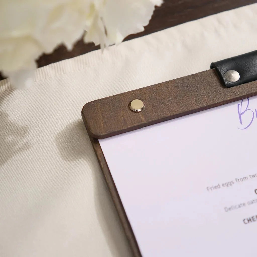 Handmade wooden menu binder with precision logo engraving.
