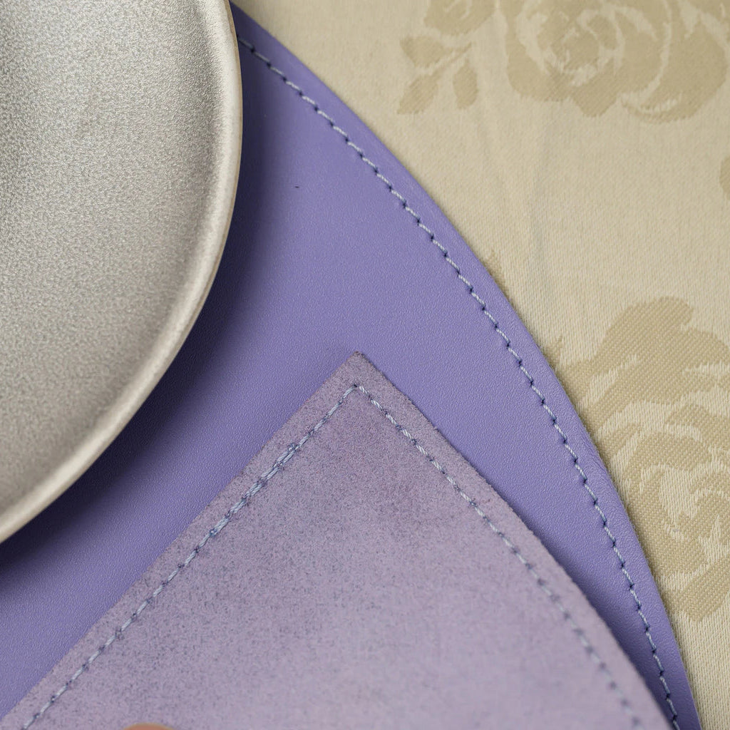 A clear, centered view of the semi-circular lavender placemat laid flat on a table, showing its symmetrical design and silver logo.