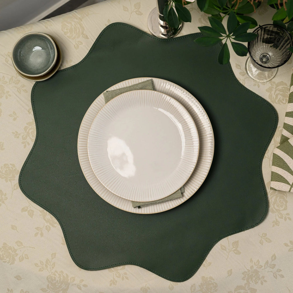 Premium forest green scalloped-edge leather placemat with a unique flower-inspired wavy shape, featuring professional tonal perimeter stitching and a smooth matte finish. High-quality heat-resistant and waterproof table protector