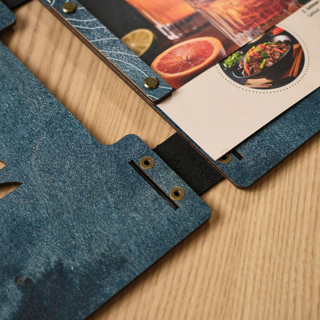 Macro view of the internal screw-post binding on a blue wooden menu cover, showing the secure metal bolts and black leather hinge.
