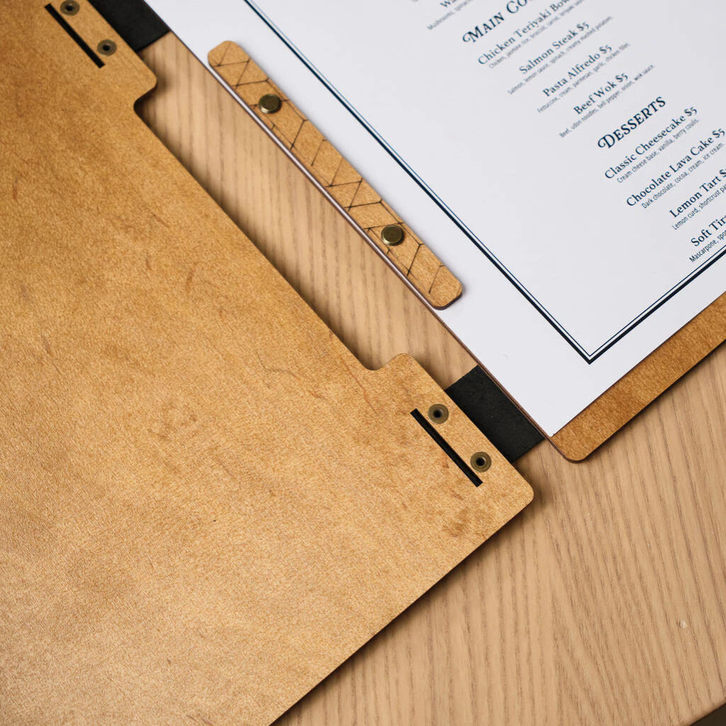 Close-up of a wooden board's binding, showing the brass screw posts and leather spine holding the menu sheet
