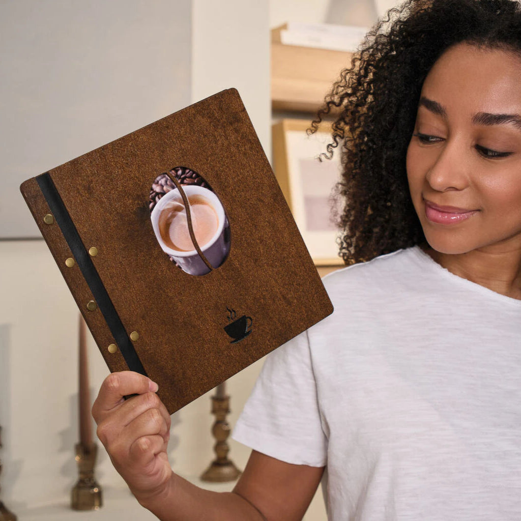 Interior view of an open wood menu showing the leather binding system and industrial brass hardware.