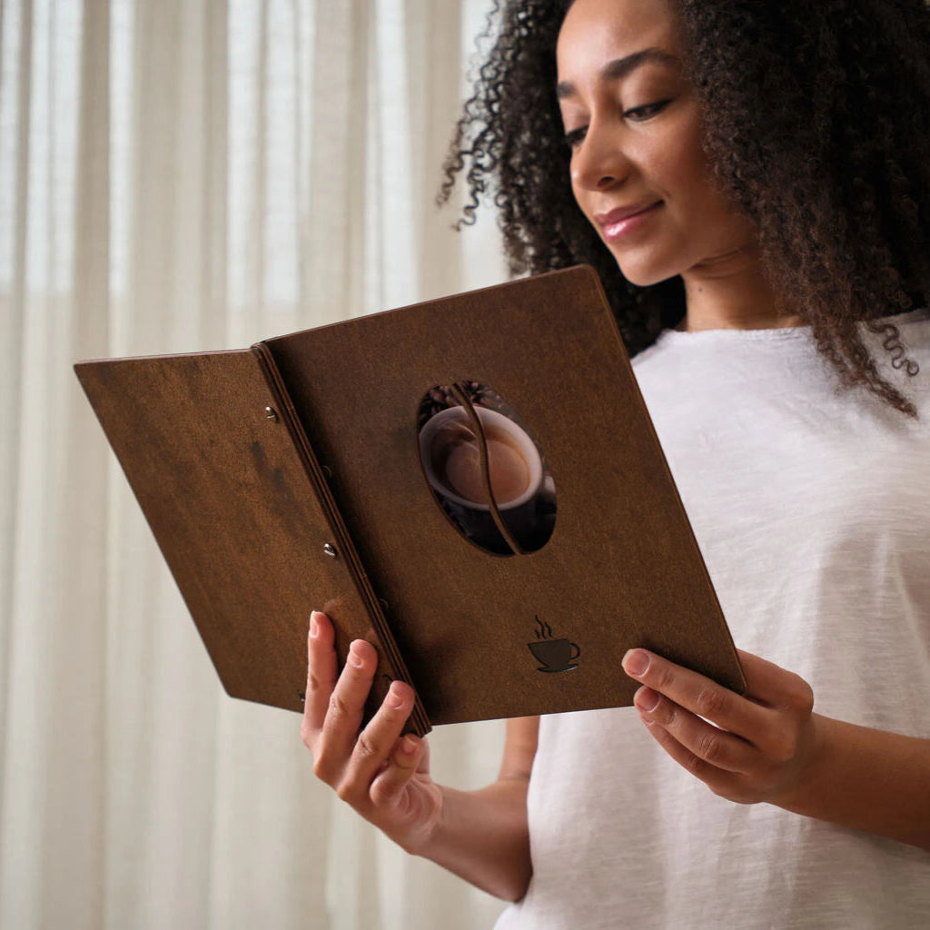 Detailed view of laser-engraved topographic lines on a deep textured wooden menu.
