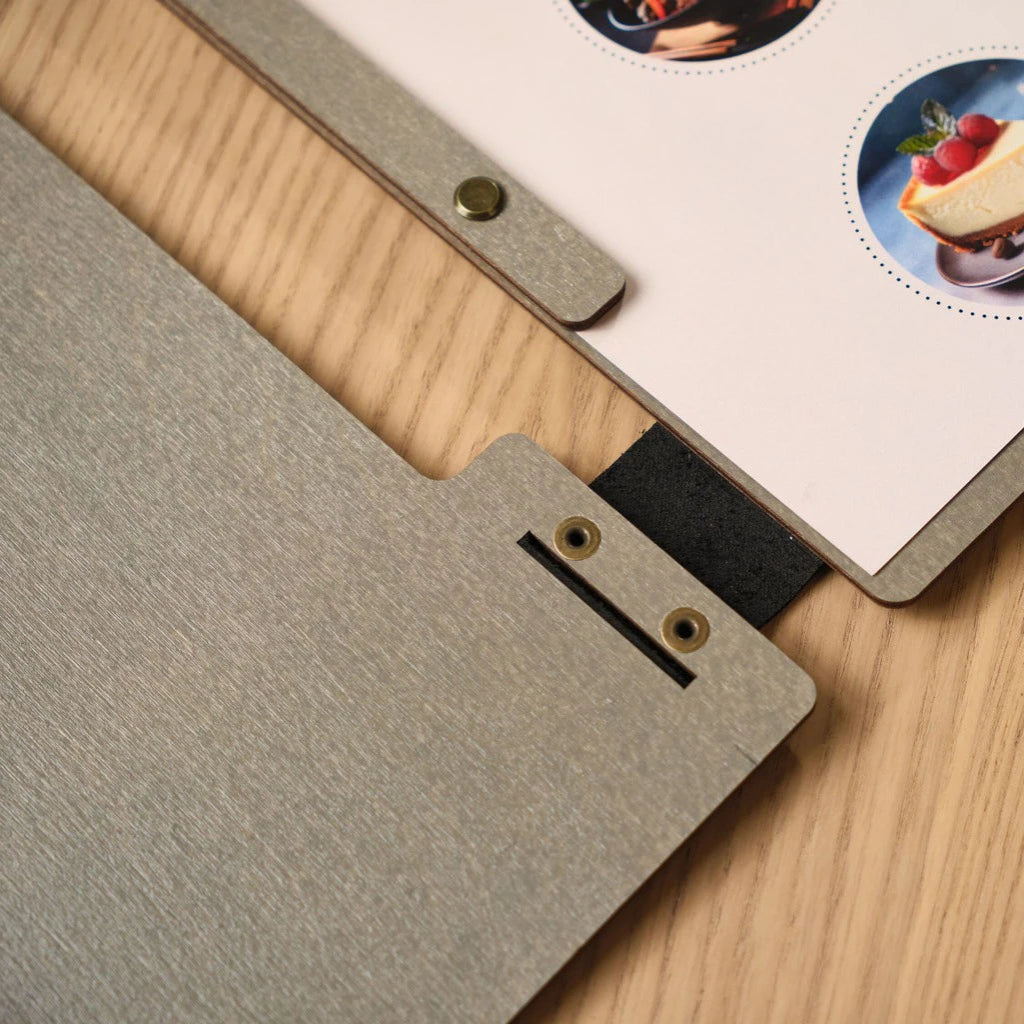 Handcrafted grey wooden menu folder interior showing professional bronze bolt binding and custom leather strap accents