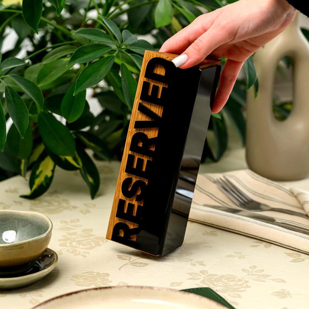 Premium restaurant table decor: a modern 'Reserved' sign crafted from natural wood and sleek black acrylic, perfect for elegant cafe and restaurant interiors
