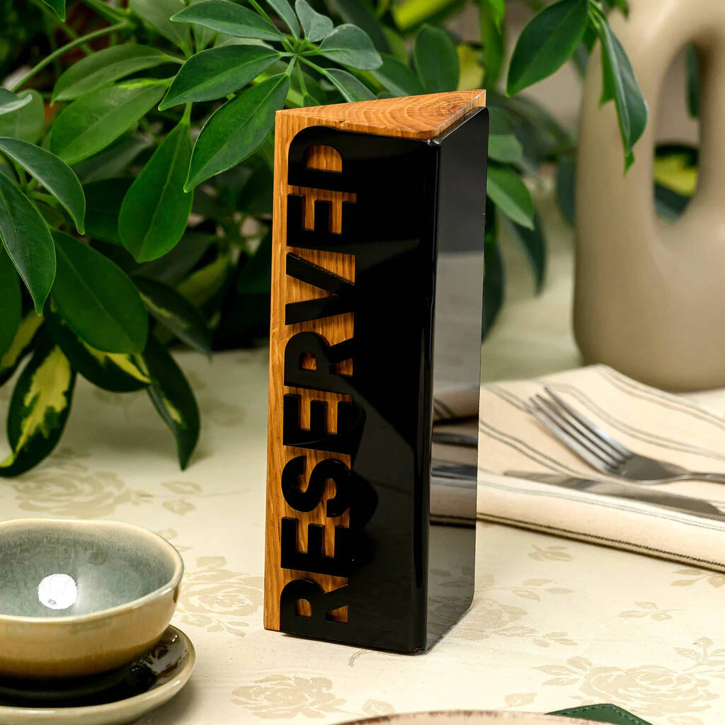 Triangular wooden 'Reserved' table sign with a black acrylic face for restaurant dining
