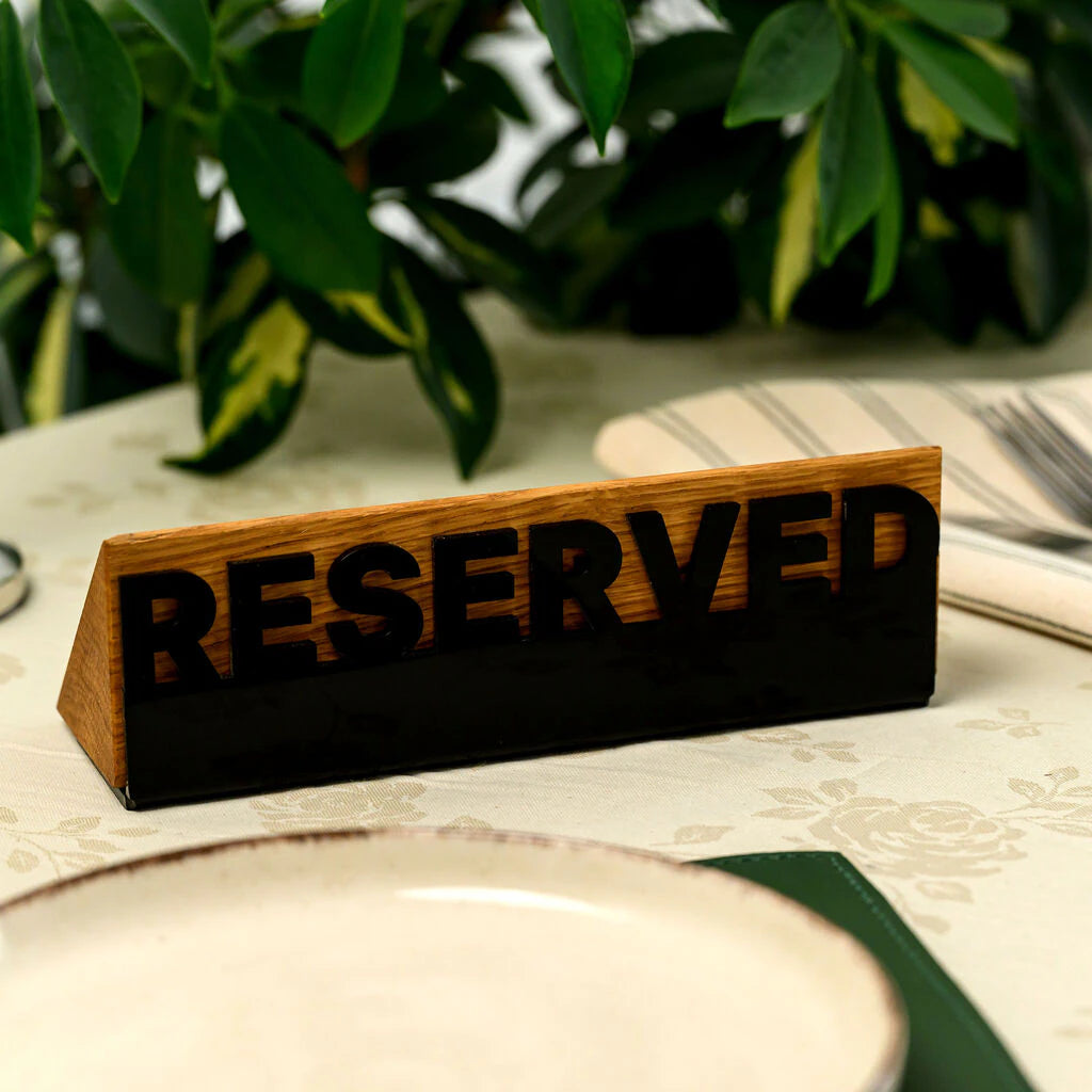 Stylish restaurant tabletop accessory: a handcrafted wooden 'Reserved' sign with a premium black acrylic finish, designed for sophisticated cafe and restaurant interiors