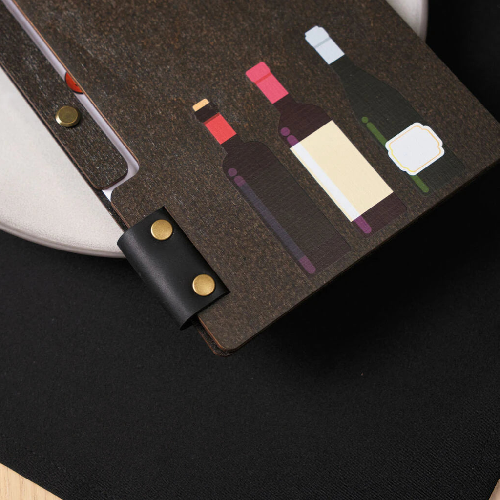 The lower right corner of the front cover is decorated with three stylized wine bottles in various colors, rendered with precision using UV printing.
