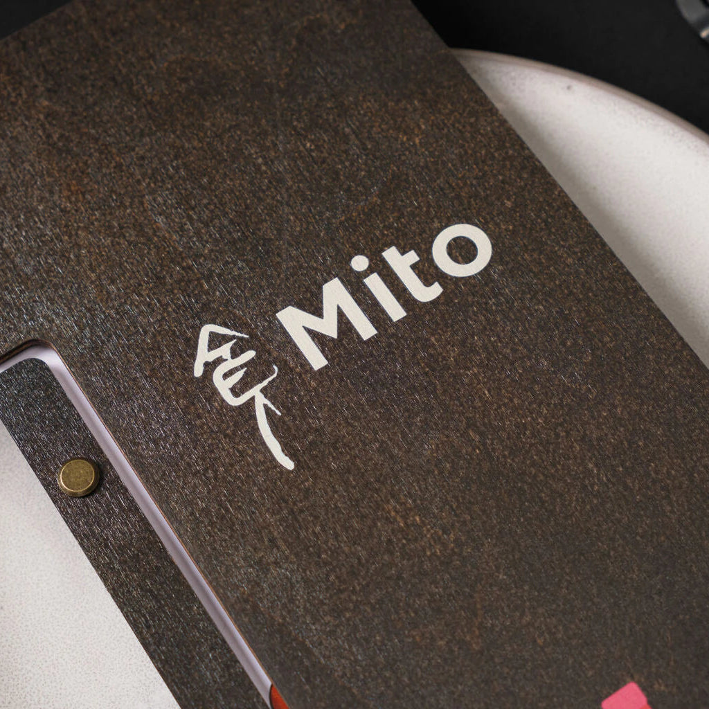 An extreme close-up showcases the texture of the wenge wood and the precision of the white UV-printed "Mito" text and symbol.