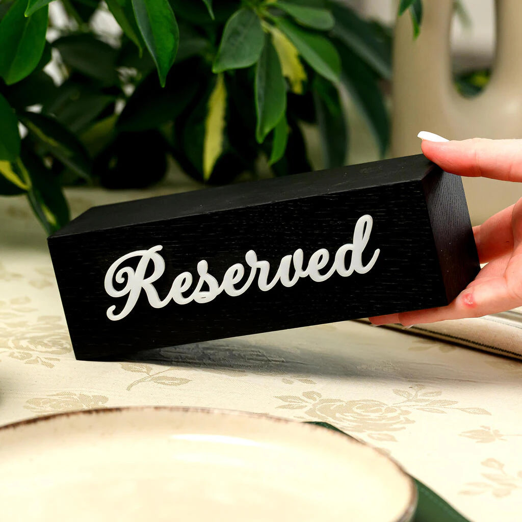 Premium black wooden reservation sign with stylish white cursive text. The contrast between the textured black oak and the smooth white acrylic lettering creates a sophisticated, modern look for cafe and restaurant table settings