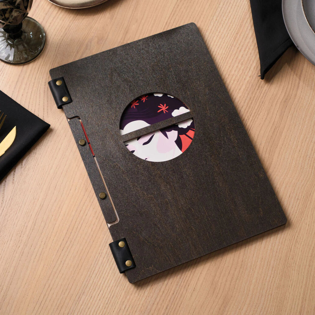 Top view of a closed dark wooden menu folder with a round window, placed on a light wooden tabletop.