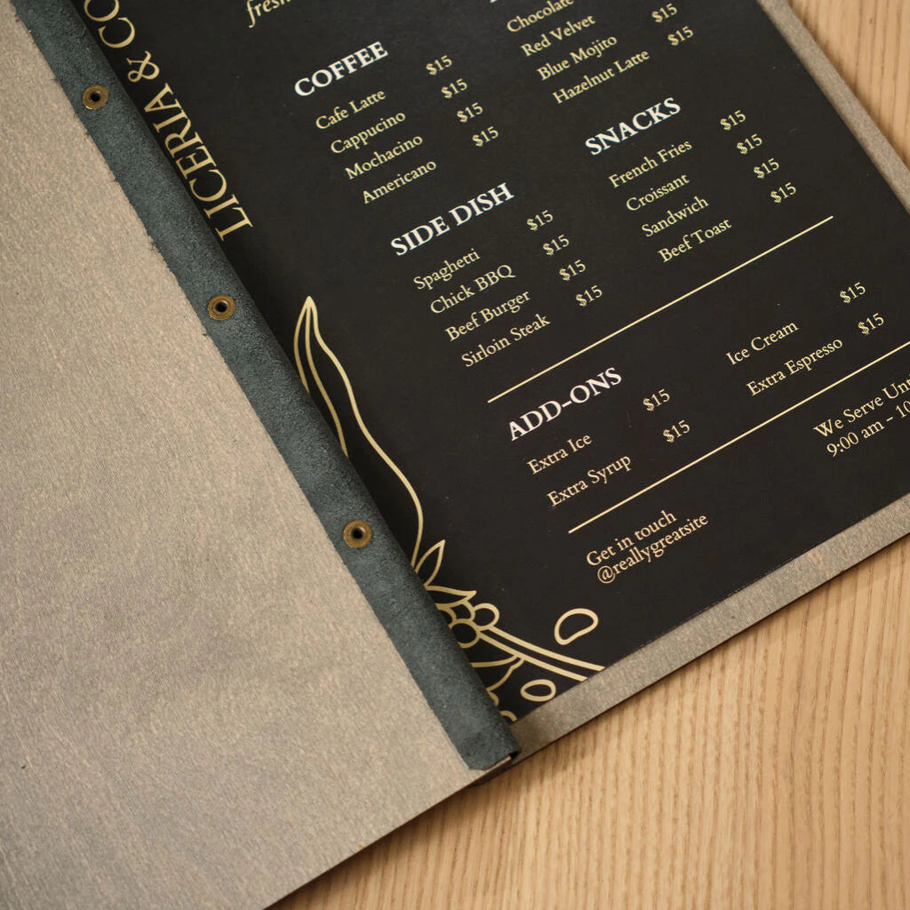 Close-up of an open wooden menu board featuring a black leather spine with brass rivets and a printed cafe menu for "Liceria & Co
