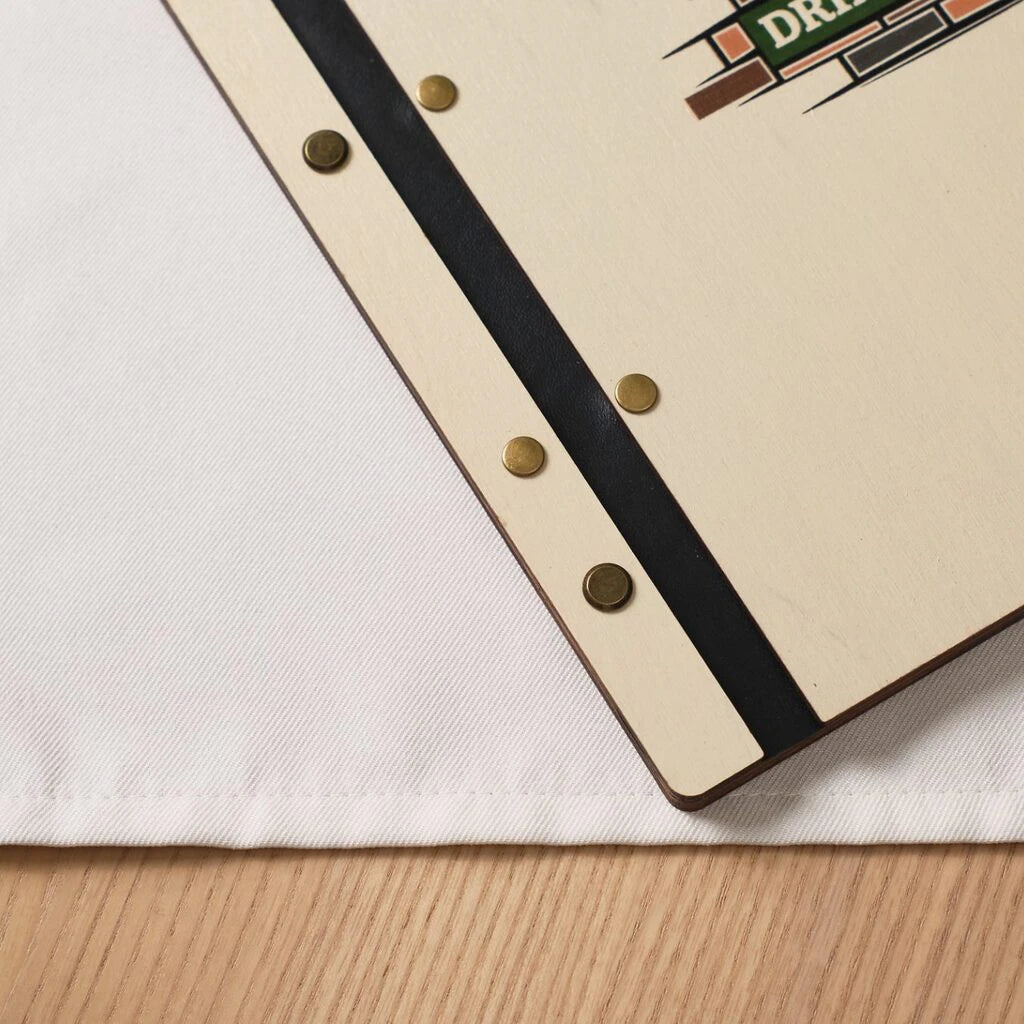 Close-up of wooden menu cover spine with black elastic leather and brass rivets with printed logo