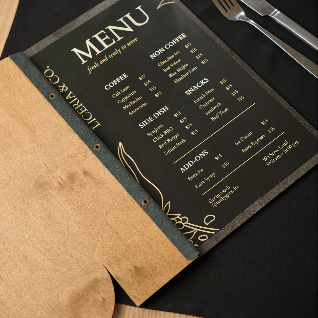 Open natural oak wooden menu folder with a custom cutout, featuring a black menu insert with gold print