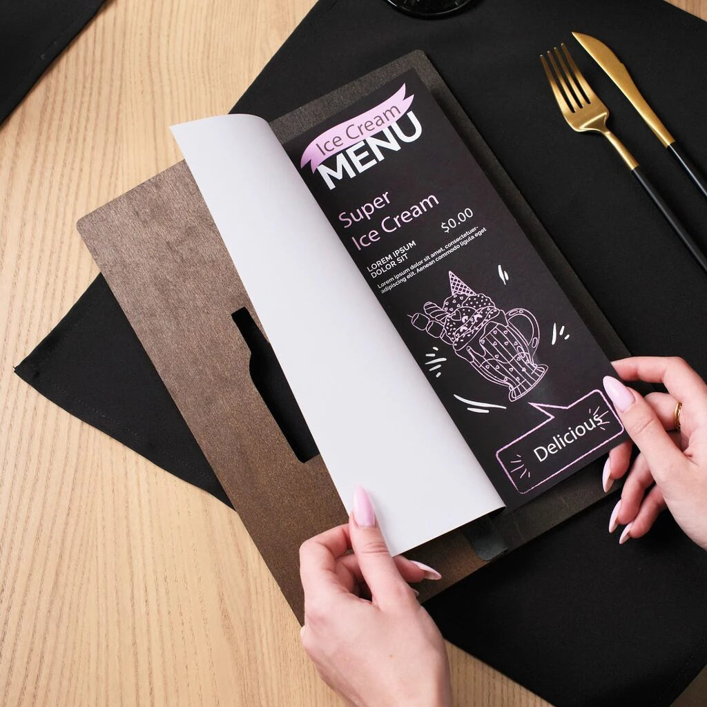 A person’s hands opening the walnut folder to reveal an "Ice Cream Menu" insert with a dark background and white illustrations.