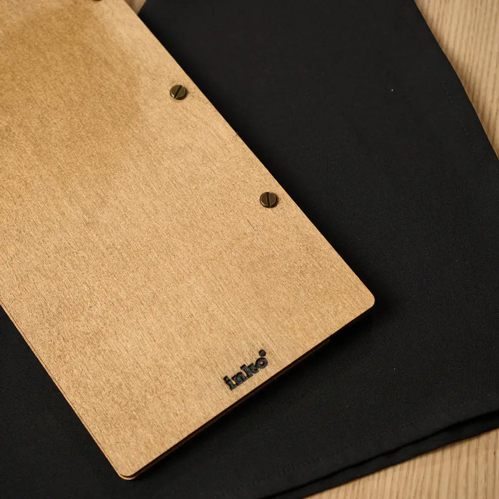 A detailed view of the lower back portion of the menu folder, displaying the black "inko" logo engraved near the bottom edge.
