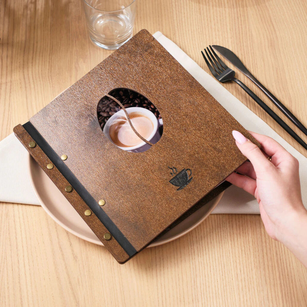 Close-up of a dark walnut wood menu cover with engraved patterns and white leather straps.
