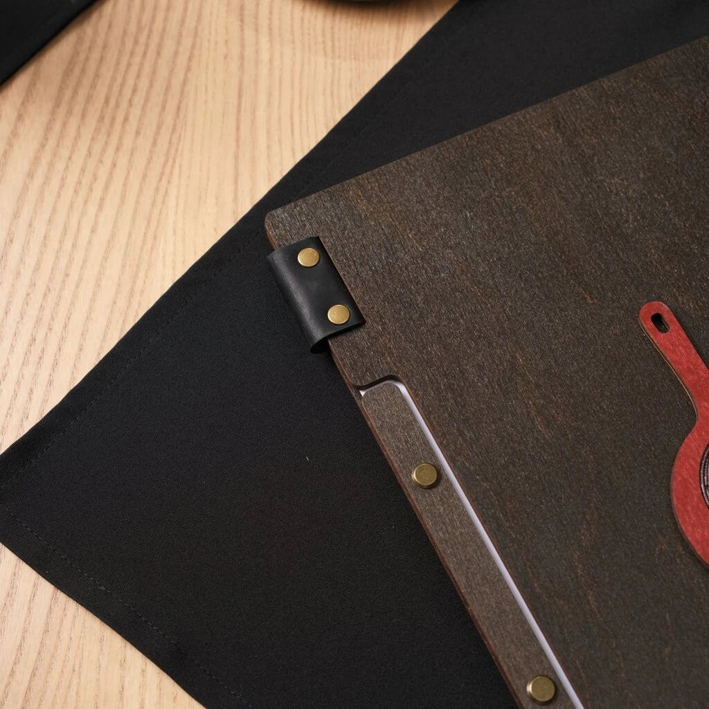 Brass-colored screws are aligned along a matching wooden strip to hold the internal menu pages in place