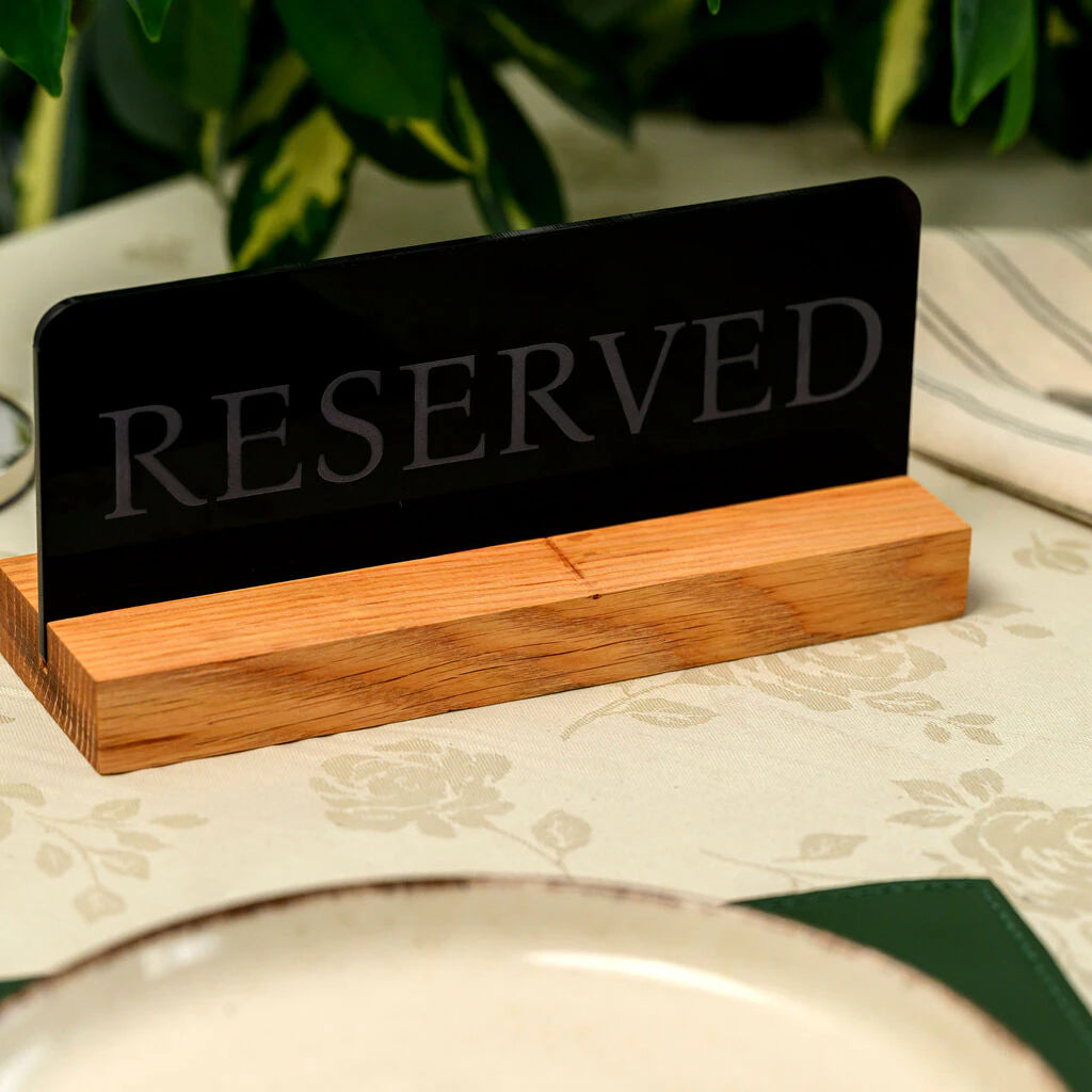 Reserved table sign for restaurants and cafes with black acrylic plate and wooden stand