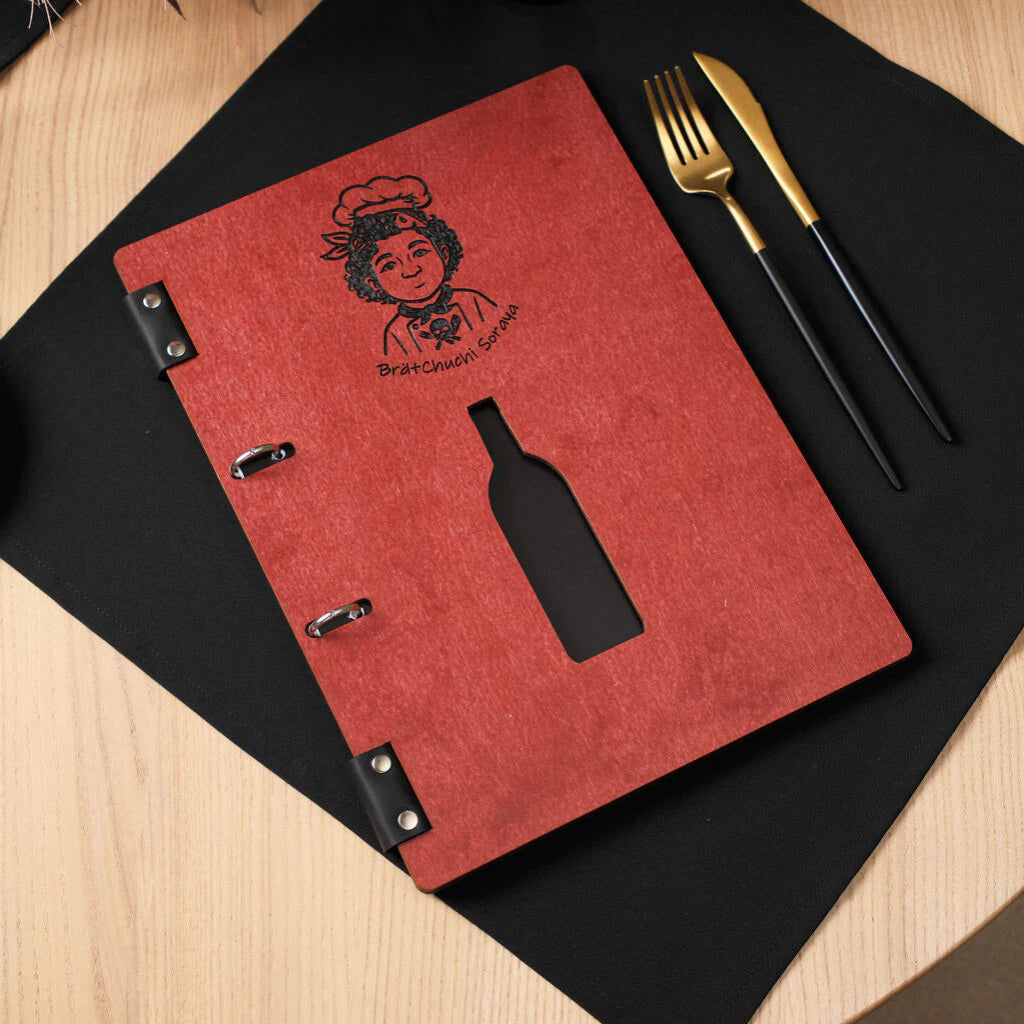 A chili-red wooden menu folder with a ring binder mechanism, featuring a black engraved chef logo and a laser-cut wine bottle-shaped window on the front cover.
